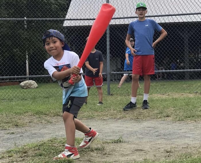 A young boy hitting a ball with a plastic bat